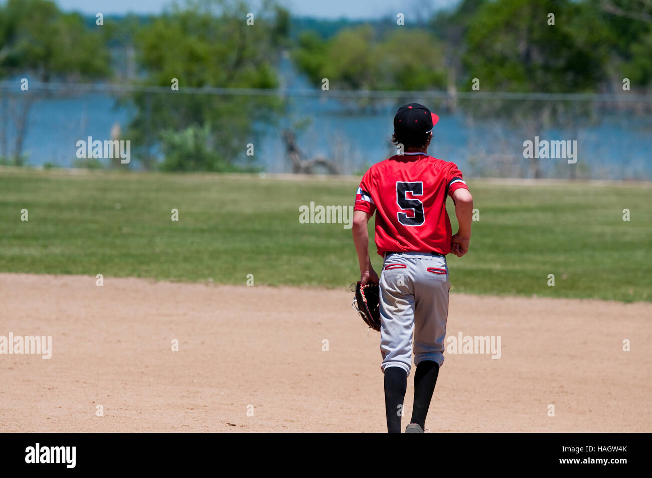 American youth baseball player running on field. Stock Photo