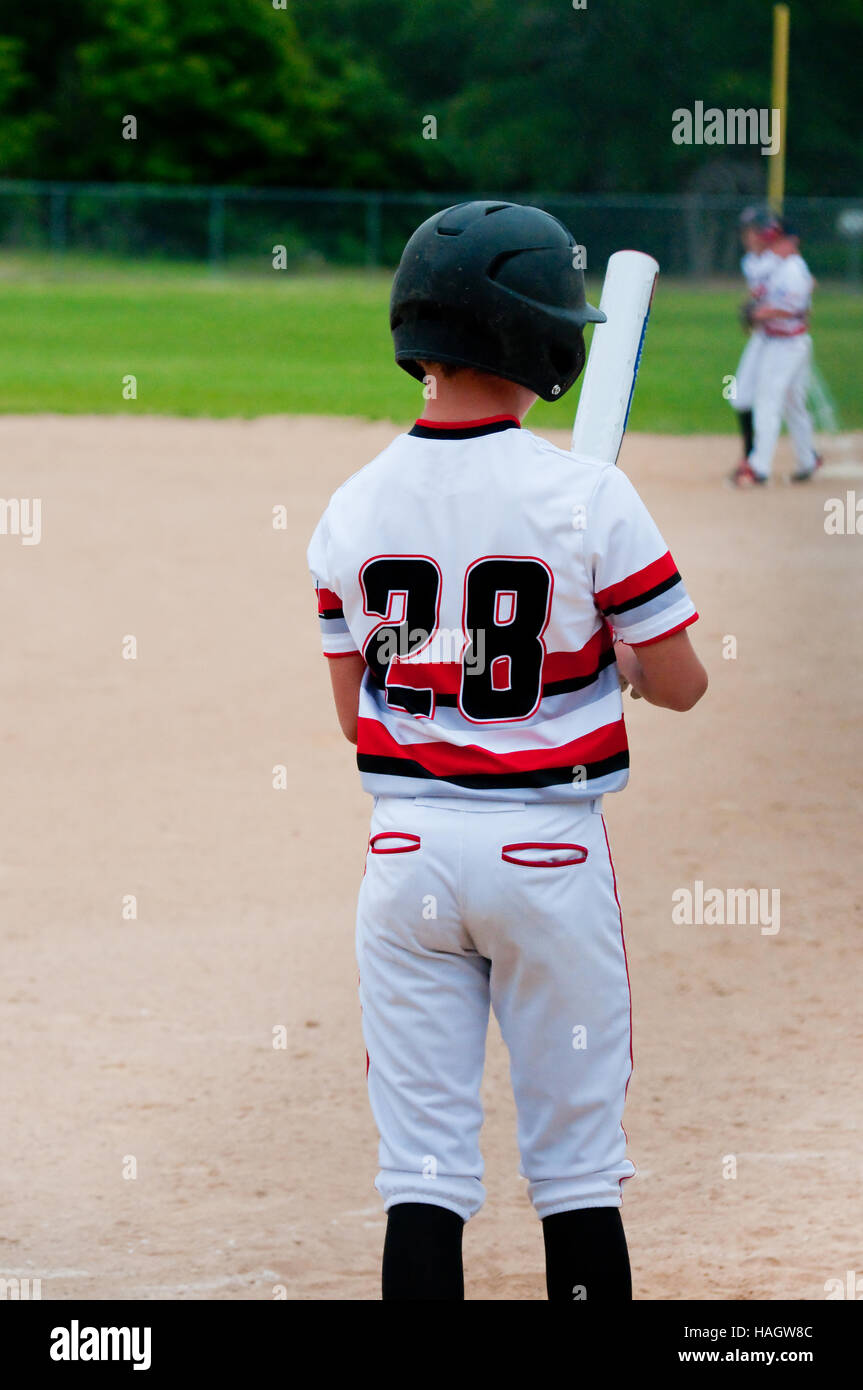 American teenage baseball player in white jersey, batting. Stock Photo