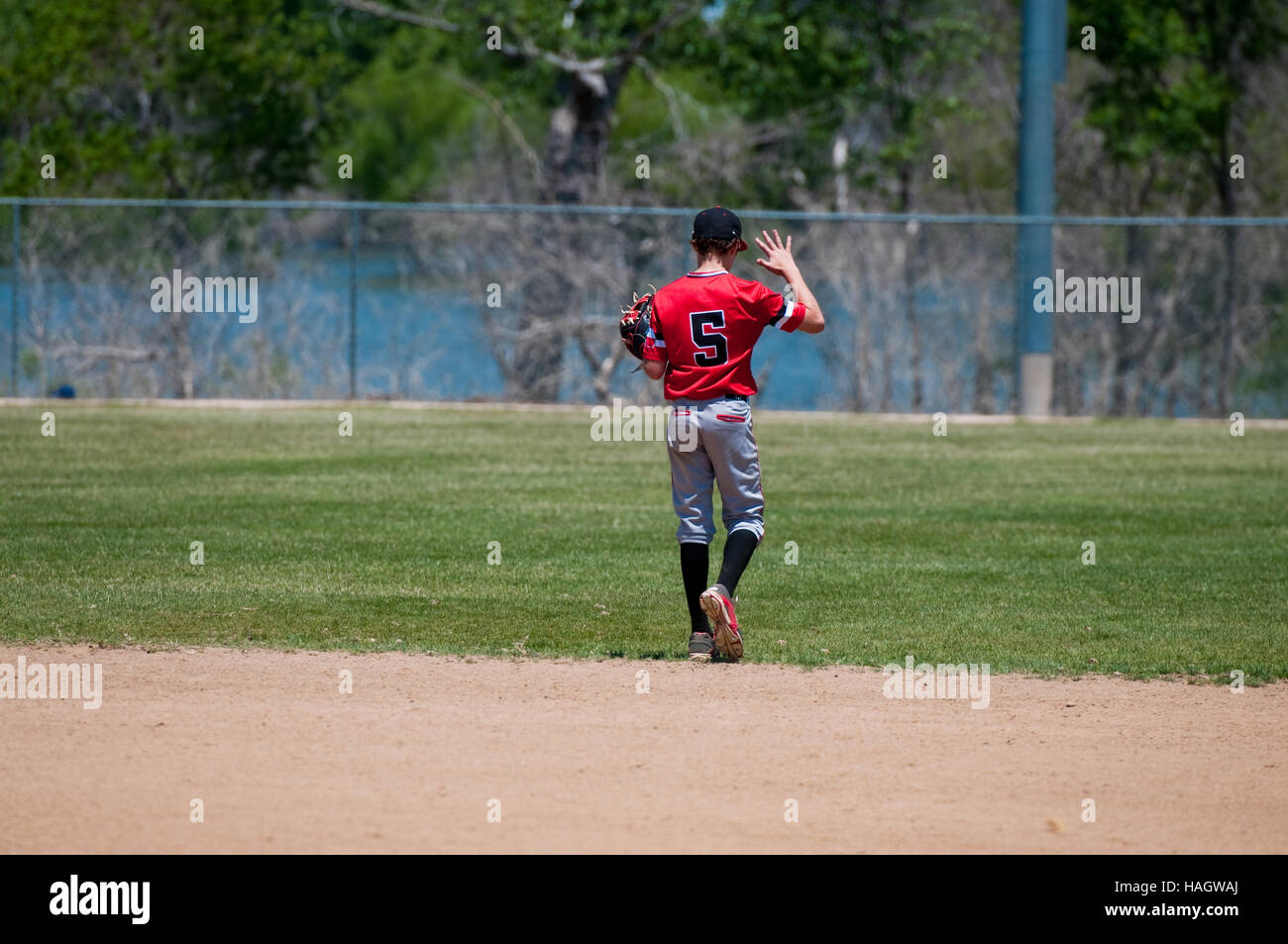 American youth baseball player holding up hand. Stock Photo