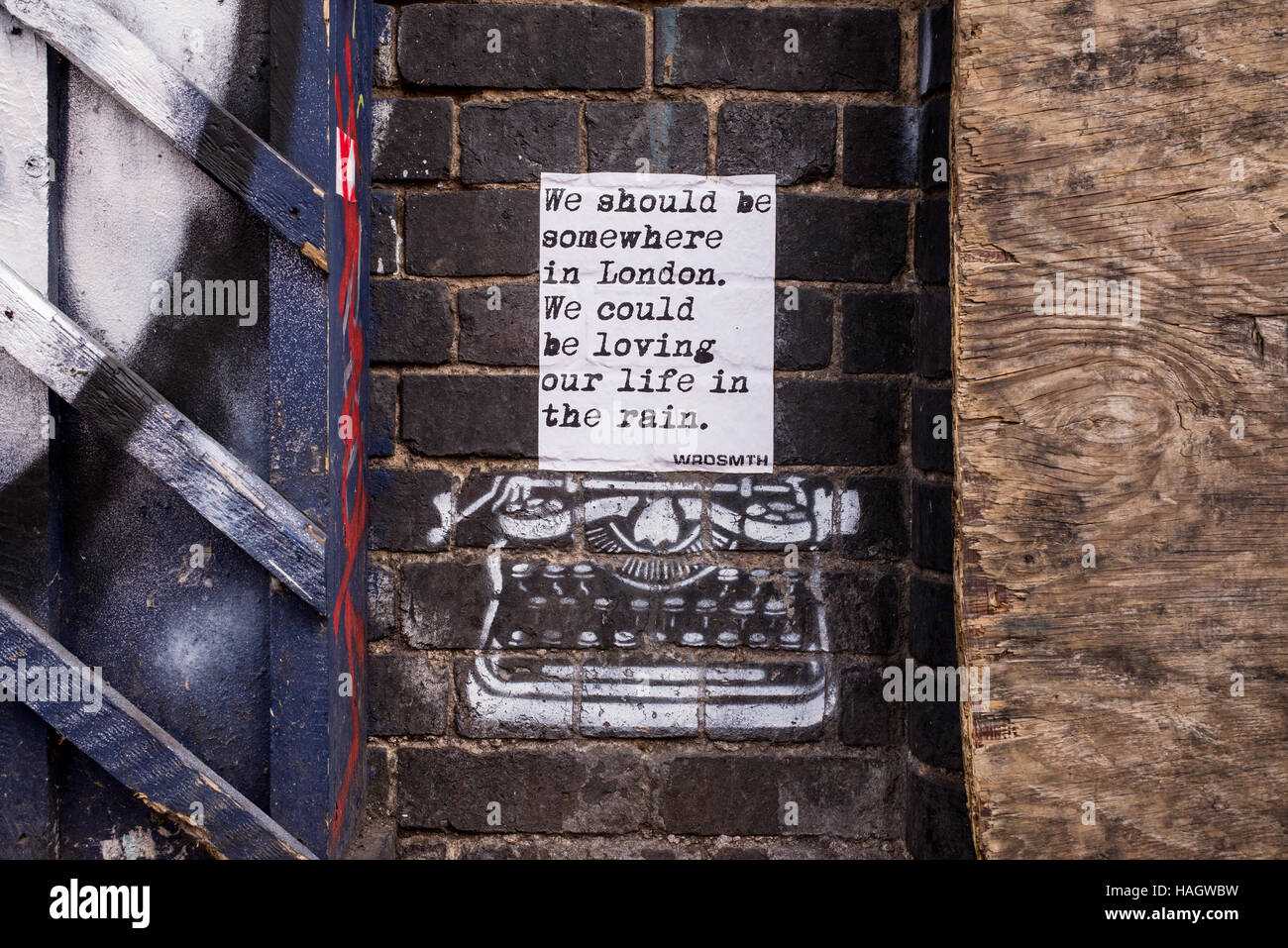 Street art mural from WRDSMTH representing typewriter on brick wall printing words adapted from song 'England' of The National Stock Photo