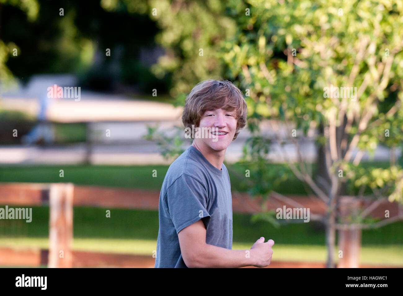 Handsome teen boy with braces and smile on face playing outdoors. Stock Photo