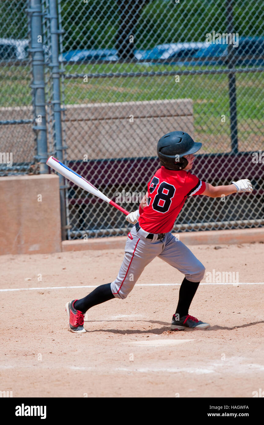 Youth baseball player after hitting the ball during a game. Stock Photo