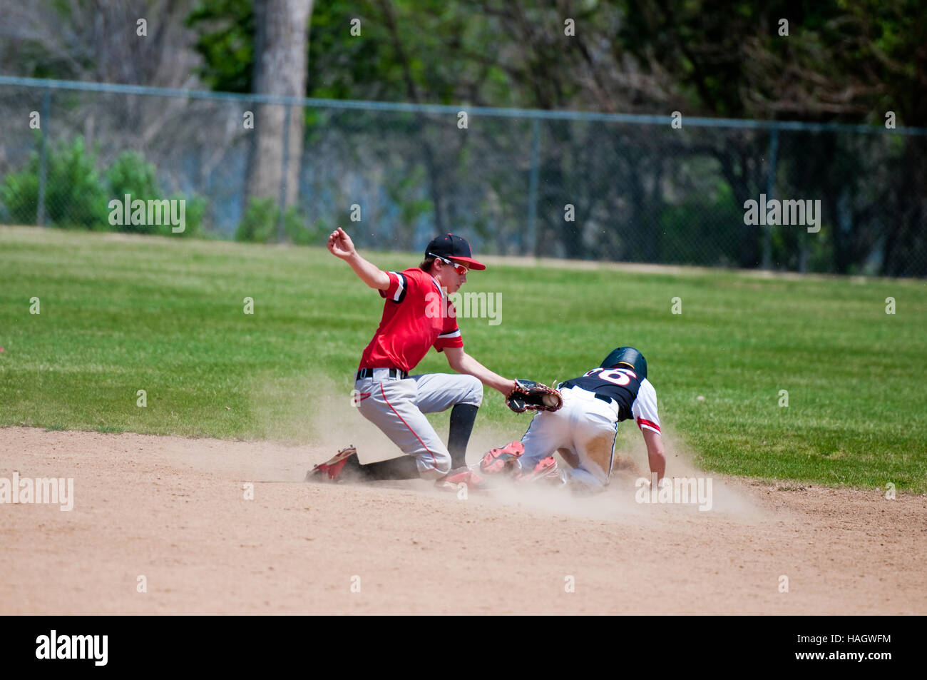 Baseball shortstop tagging out a player sliding at second base. Stock Photo