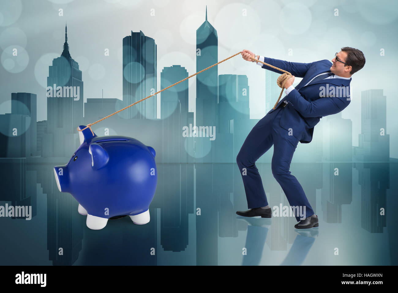 Businessman pulling piggybank with rope Stock Photo - Alamy