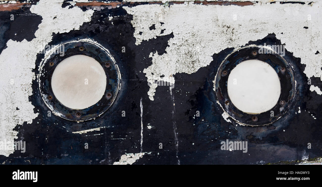 2 round portholes on an old, weathered boat Stock Photo