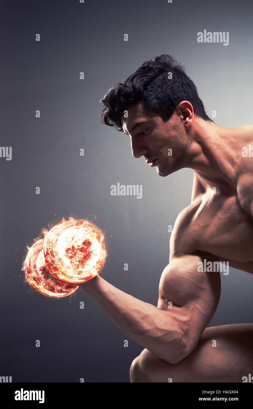 Muscular ripped bodybuilder with burning dumbbells Stock Photo - Alamy