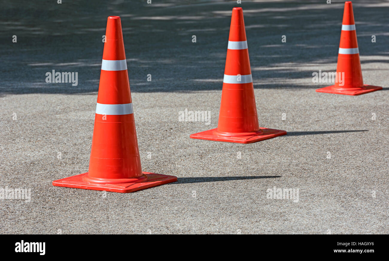 bright orange traffic cones standing in a row on the road Stock Photo