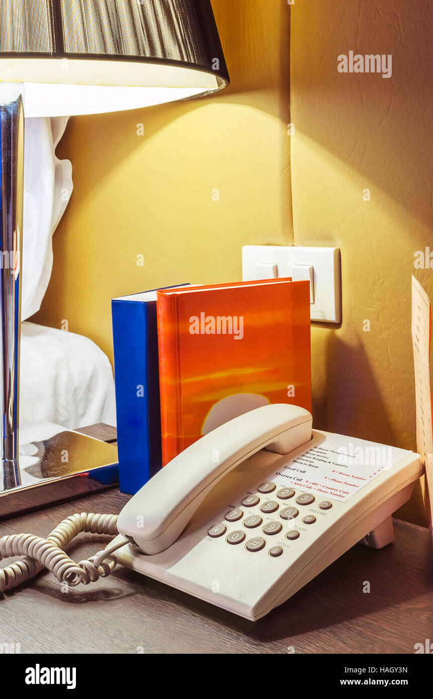 Phone on Bedside table in hotel's room. Stock Photo