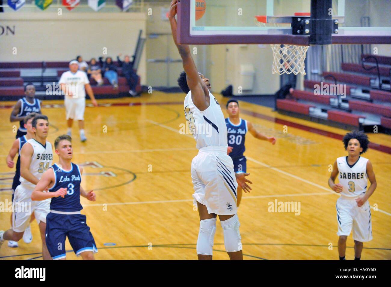 A player elevating well off the floor to slam home two points from above the basket during a high school basketball game. USA. Stock Photo