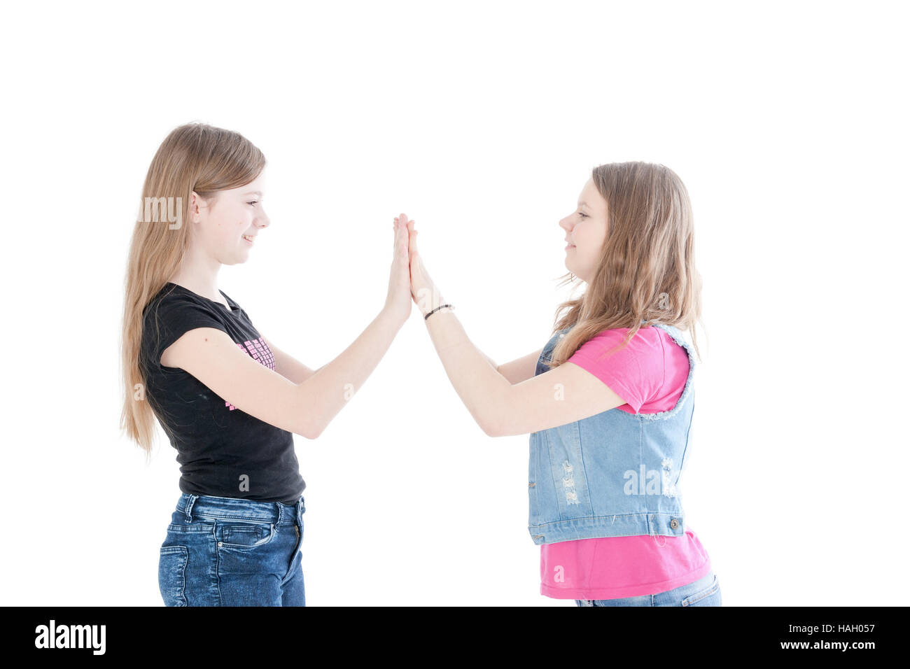 two smiling young beautiful girls on a white background Stock Photo - Alamy
