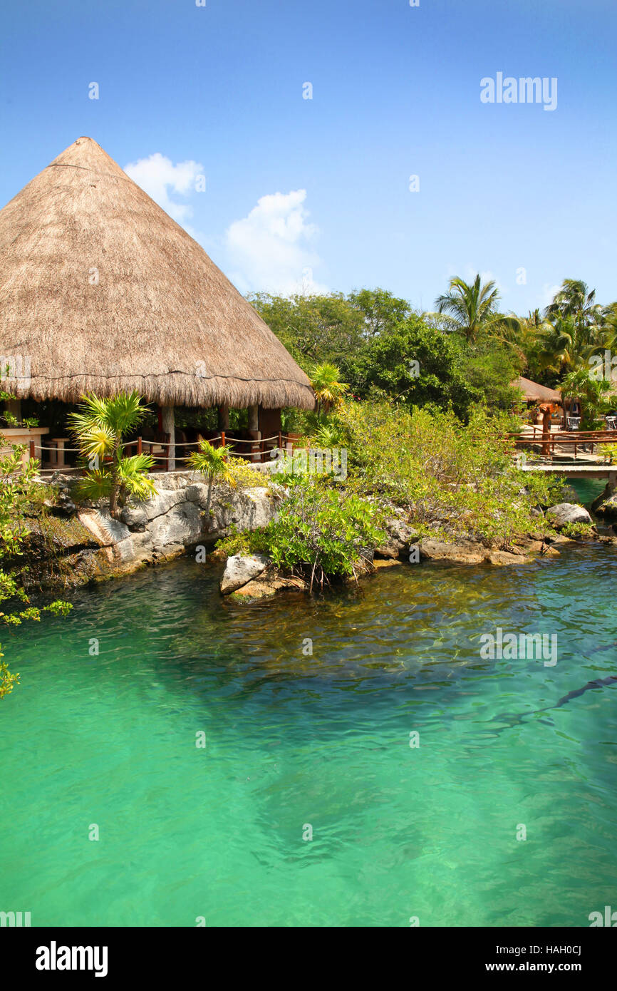 Tropical Mexican coastline with typical thatched roof hut & turquoise waters. Stock Photo