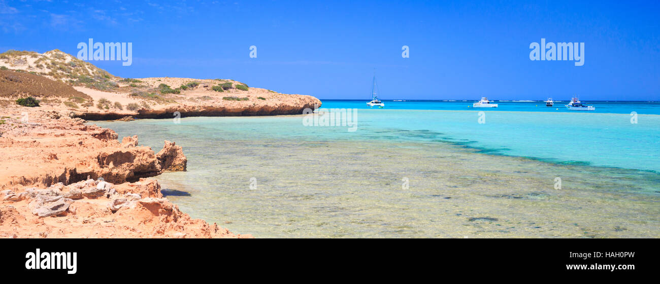 Monck Head in Coral Bay, Western Australia with boats moored in the ocean. Stock Photo