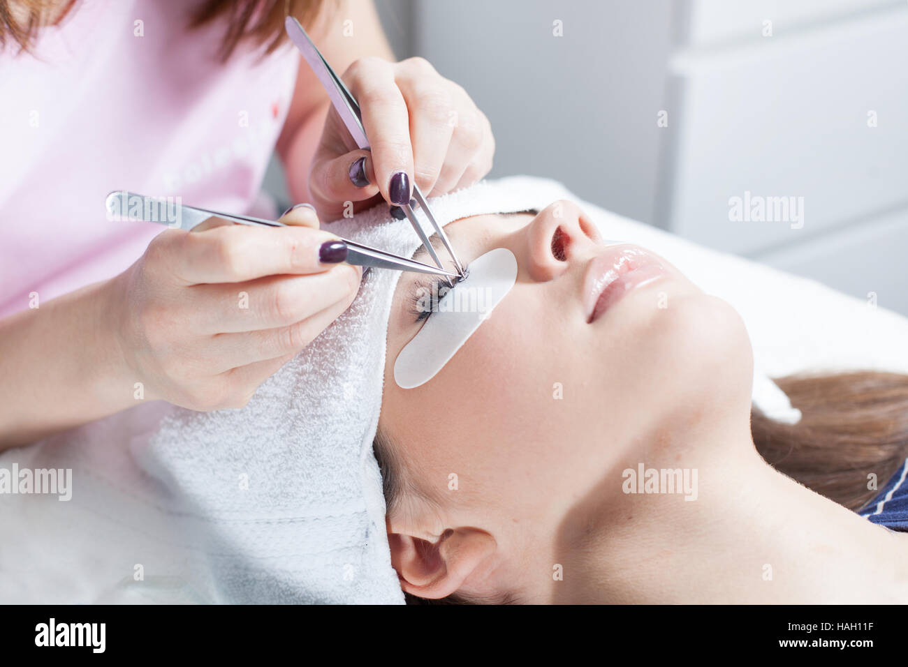beautician making artificial lashes. eyelash extension procedure Stock Photo