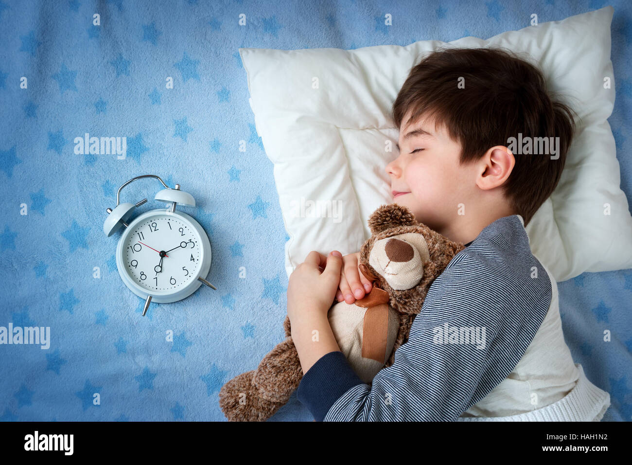 six years old child sleeping in bed with alarm clock Stock Photo Alamy