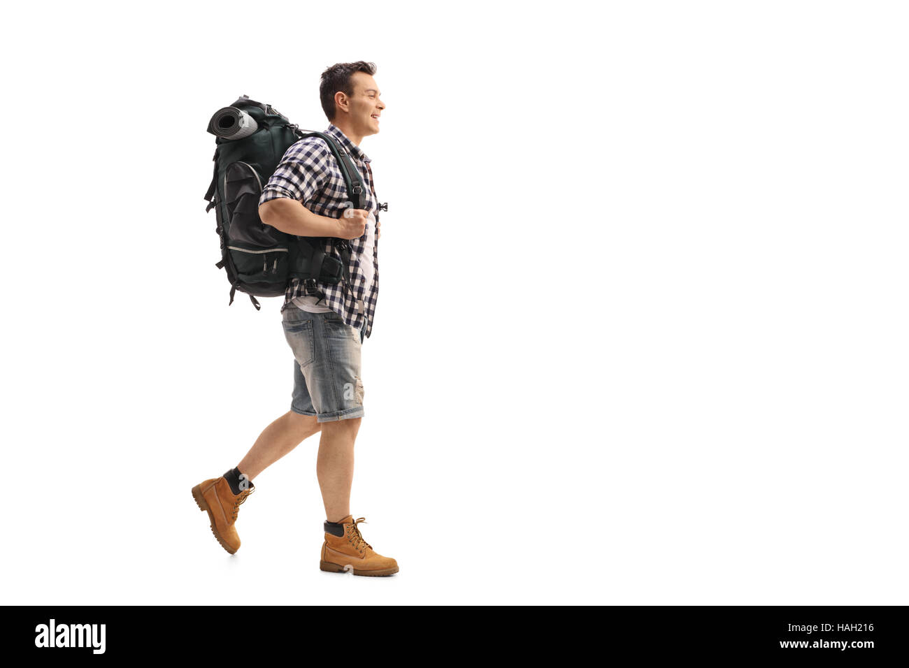 Full length profile shot of a young hiker walking isolated on white background Stock Photo