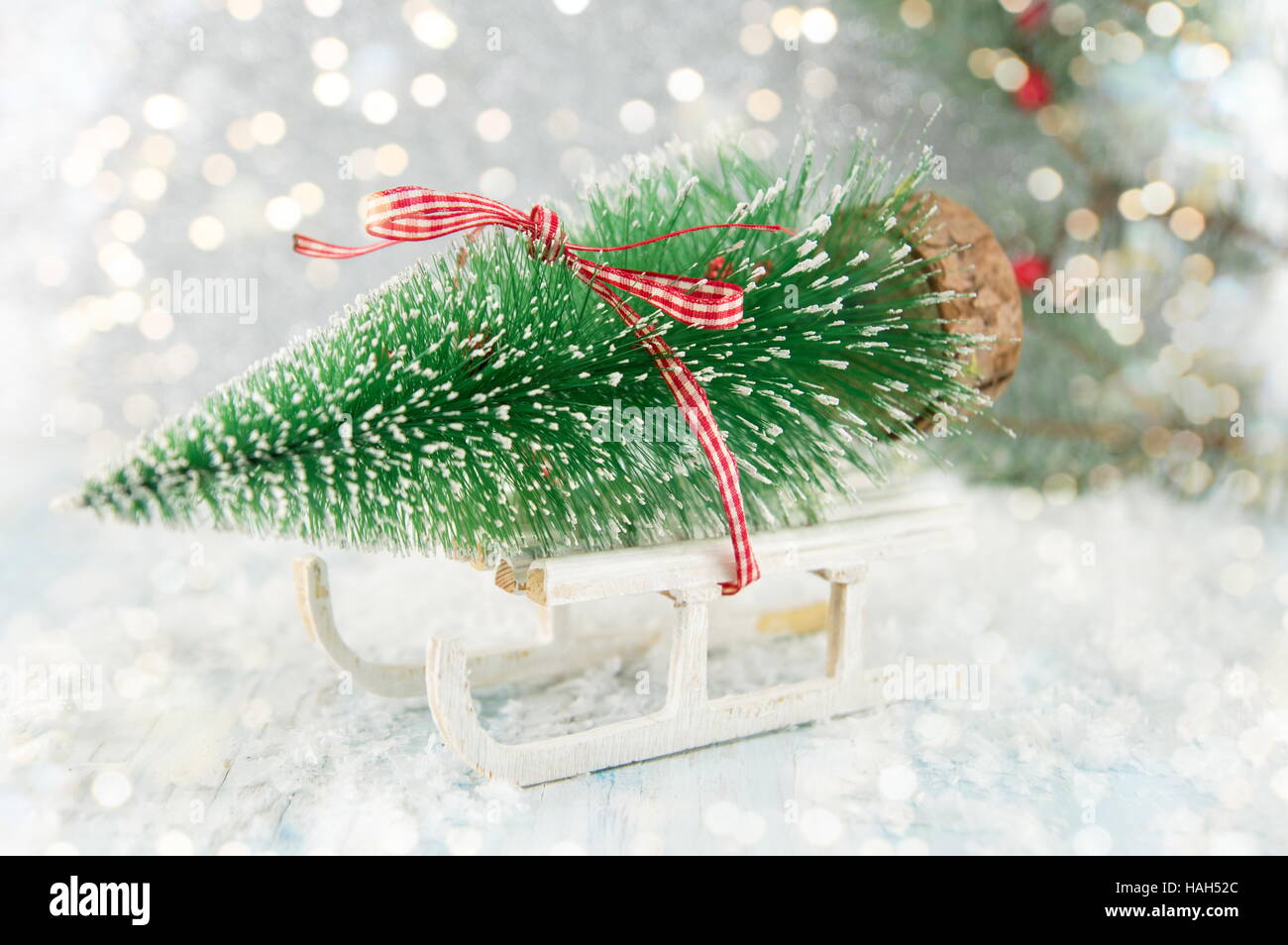 Small sleigh carrying a toy  Christmas tree Stock Photo