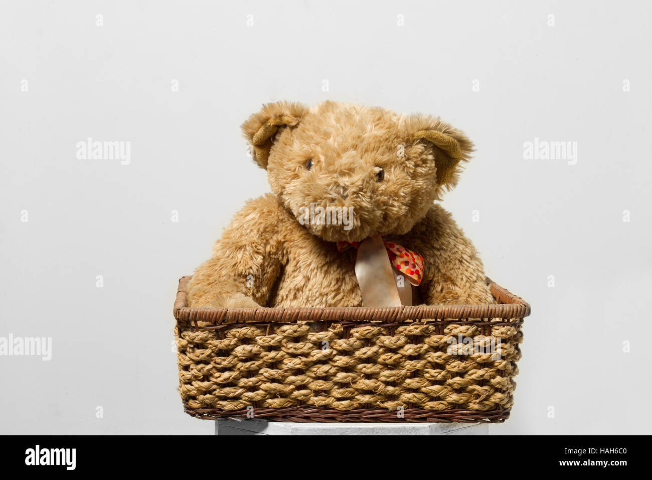 The toy teddy bear in basket isolated on grey background Stock Photo ...