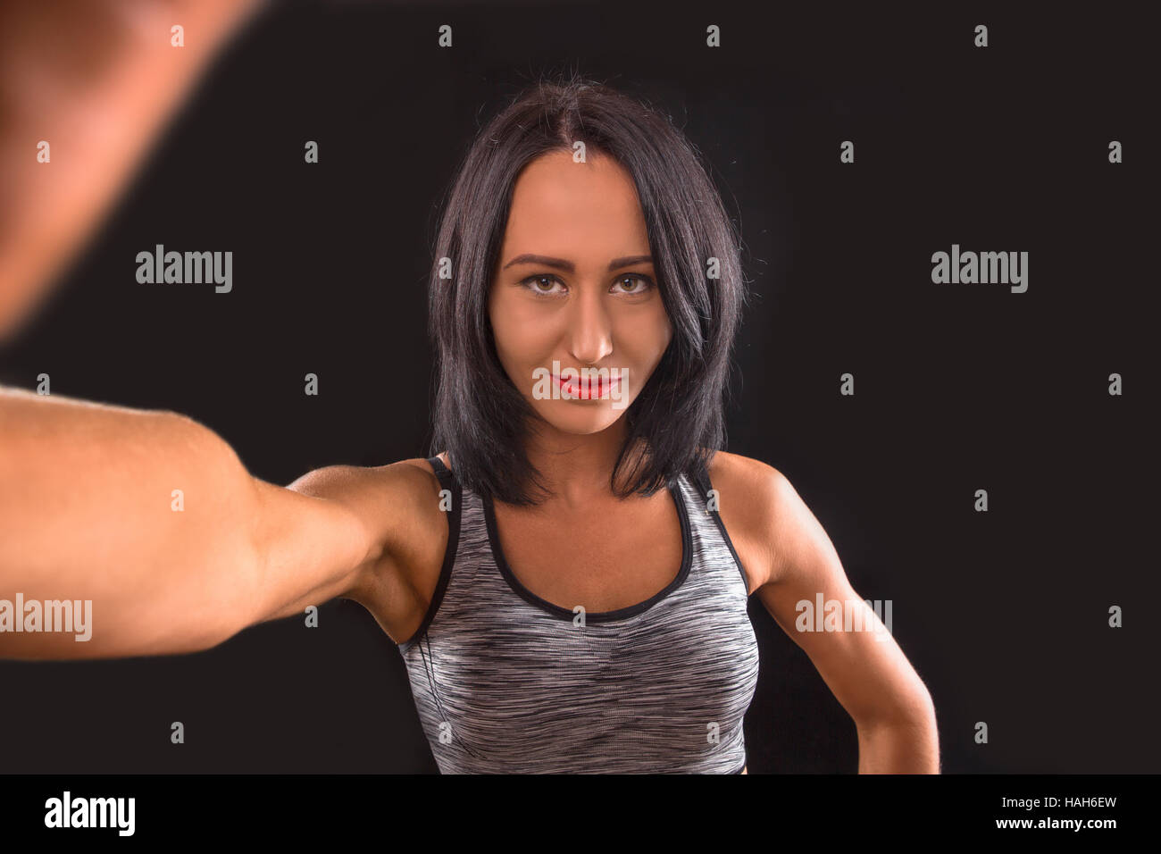 Female athlete flexing biceps, portrait stock photo
