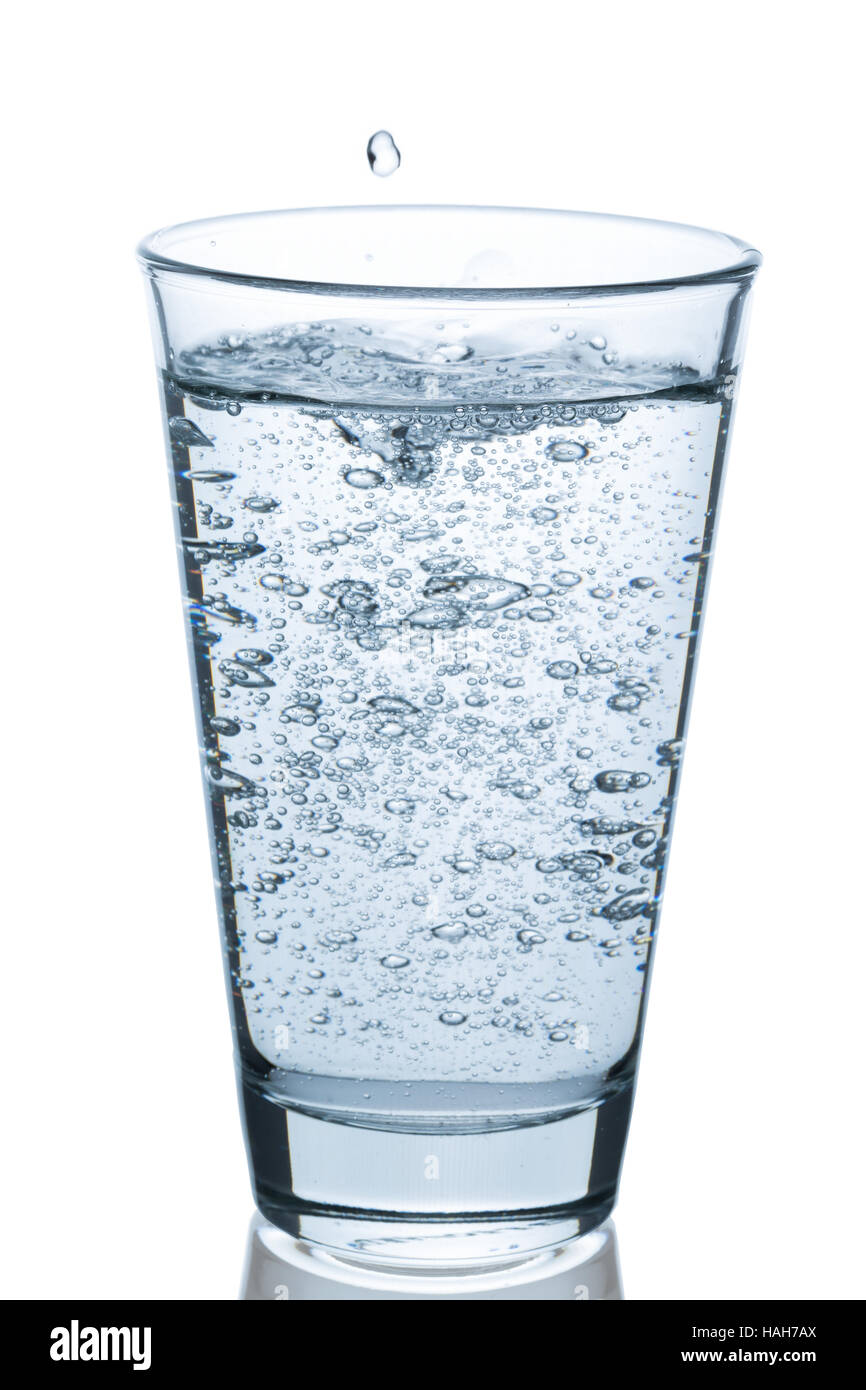 Glass of bubbling water on white background Stock Photo