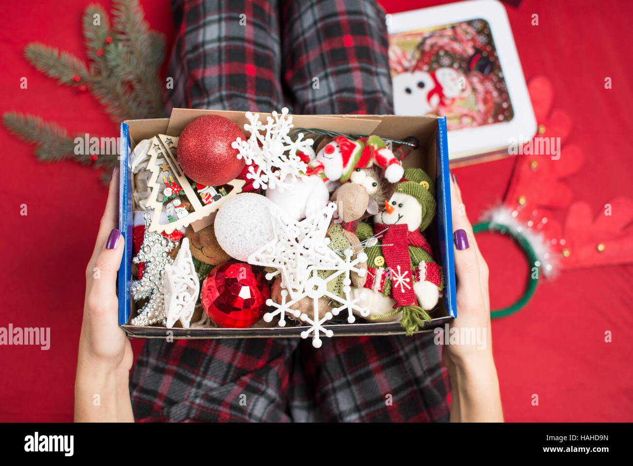 female holding an opened christmas  decoration box in pyjamas Stock Photo