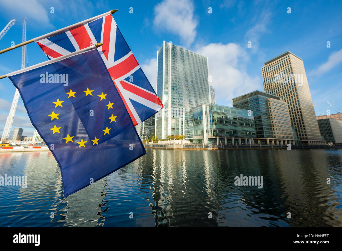 European Union and Union Jack flags flying above reflections of modern business towers of London's new financial district Stock Photo