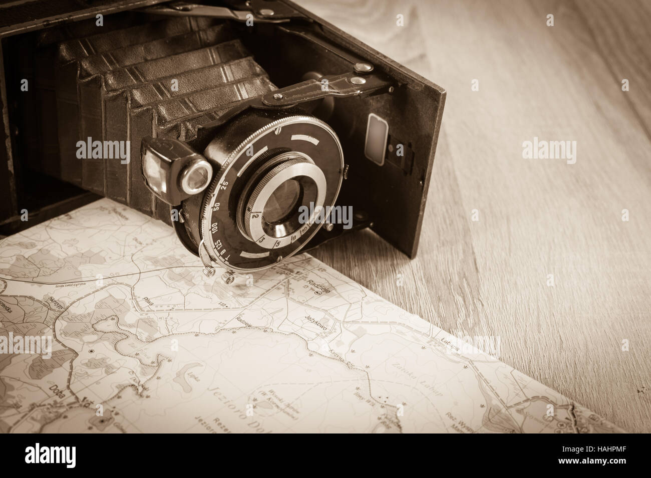 Old folded Leica camera with prontor lens on a map of lakes in Poland. Obsolete camera on a map. Stock Photo