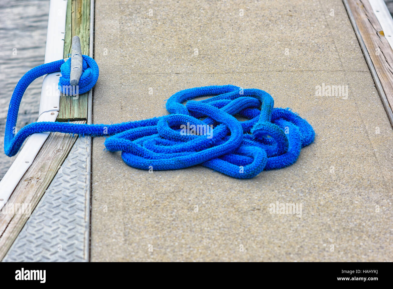 Blue mooring rope tied off to a cleat Stock Photo