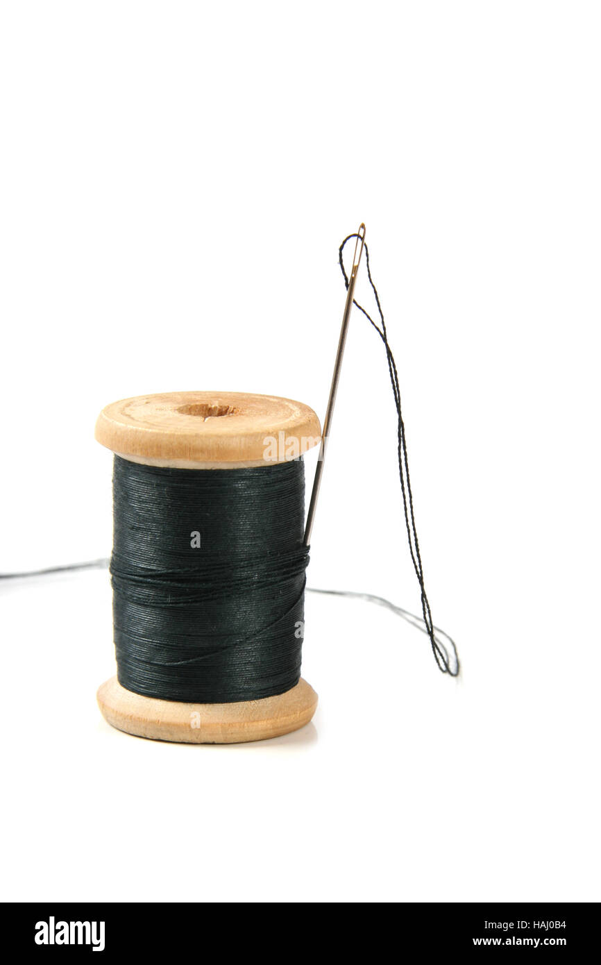 Black thread spool with needle Stock Photo - Alamy
