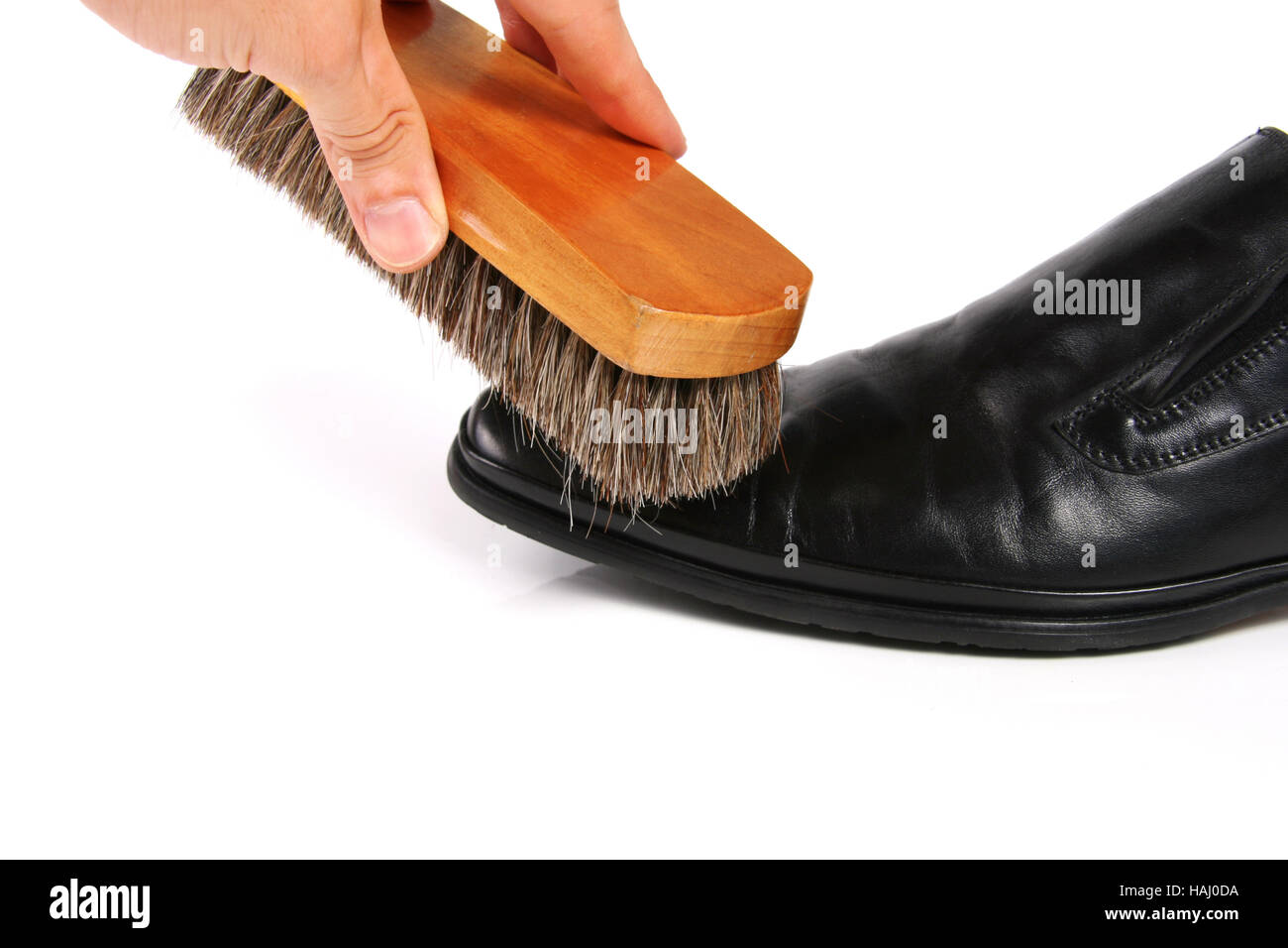 hand with brush cleaning shoe Stock Photo