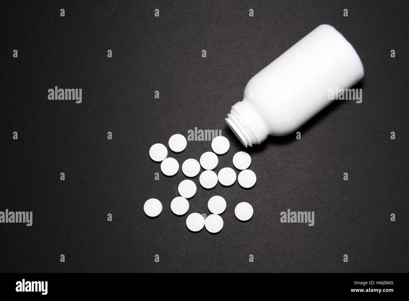 white pills on black background Stock Photo