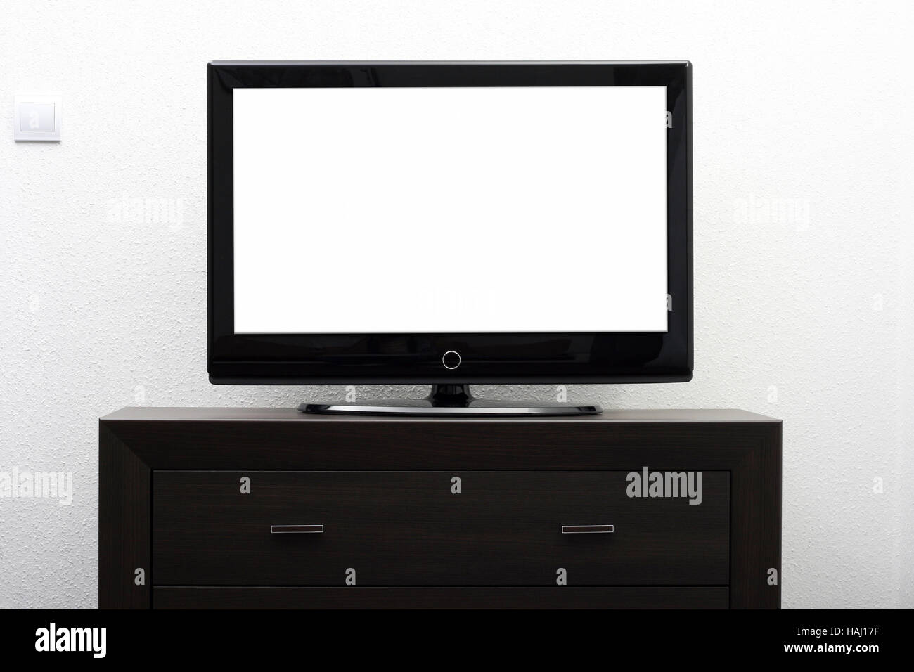 blank tv screen on brown commode against white wall Stock Photo