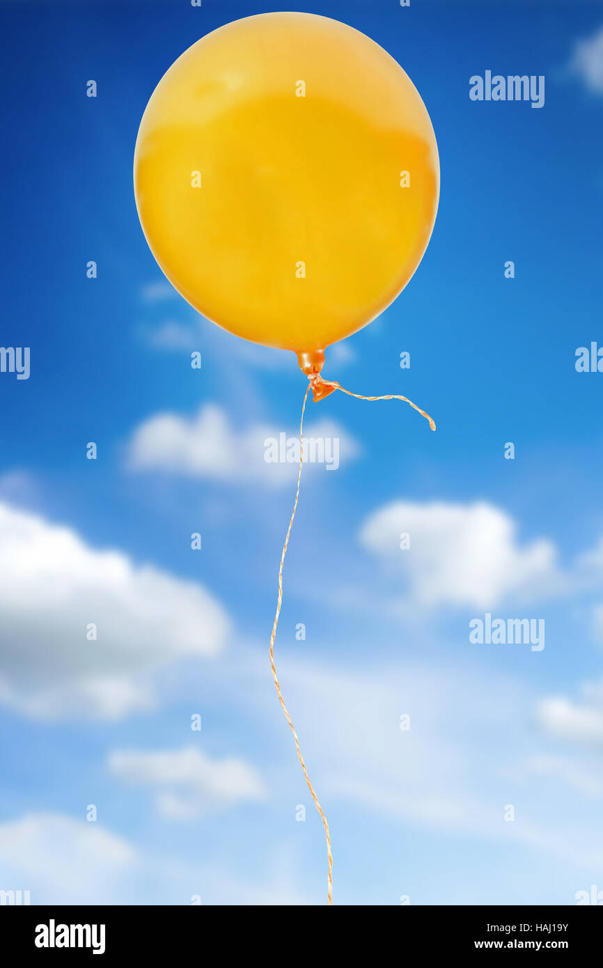 orange balloon with rope flying in the sky Stock Photo
