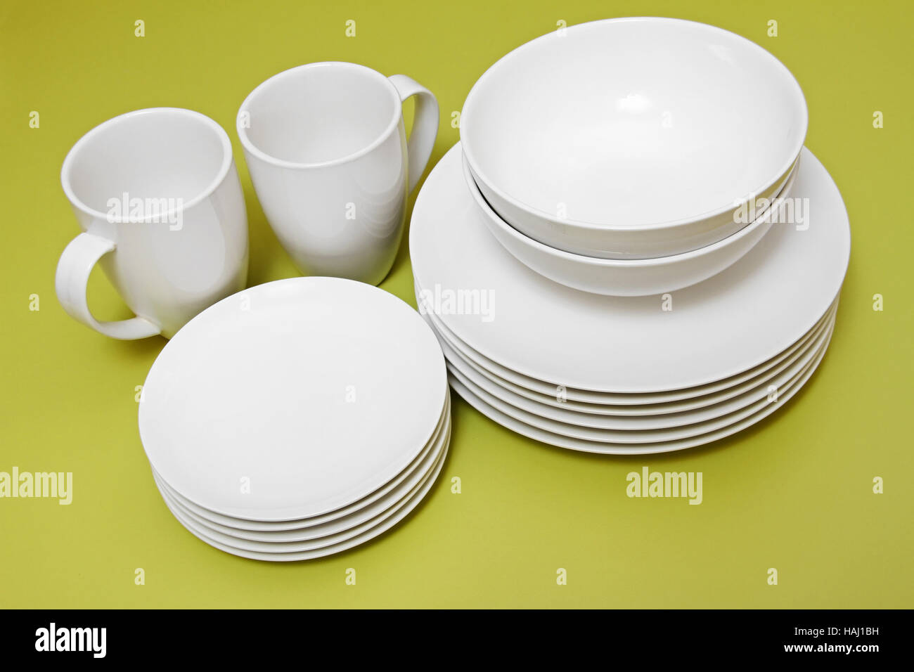 clean plates bowls and cups on green table Stock Photo