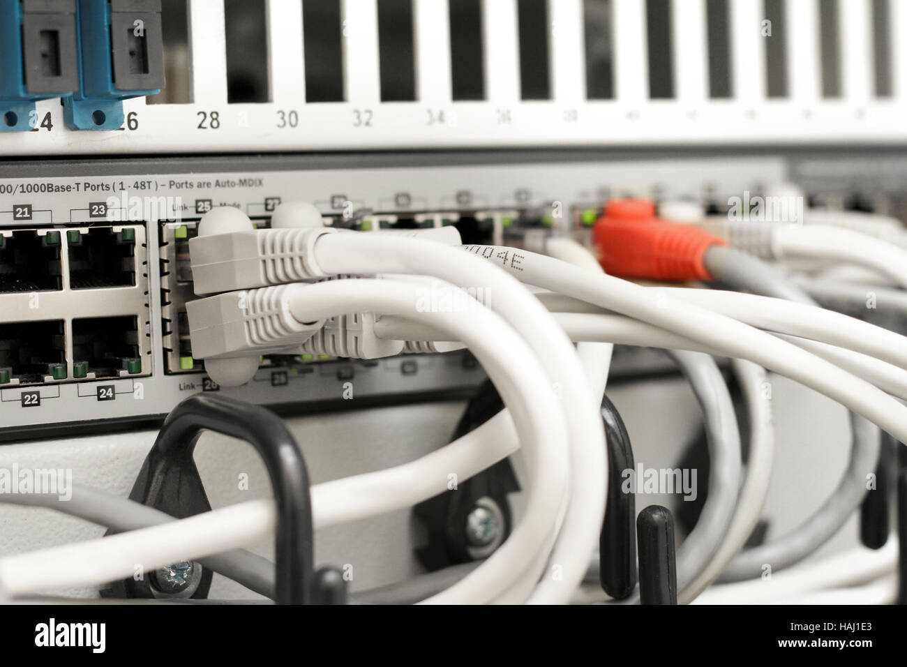network hub and cables connected to servers in a datacenter Stock Photo