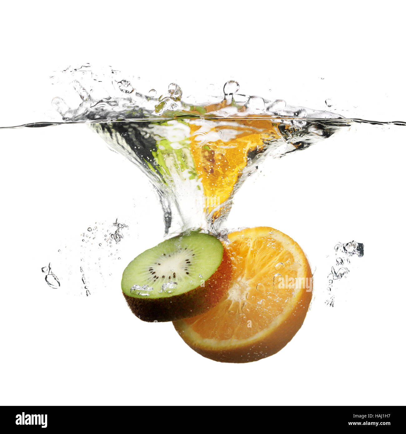 fruits dropped in water with splash on white Stock Photo