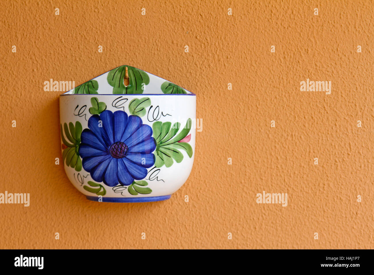 colorful empty flower pot on orange wall Stock Photo