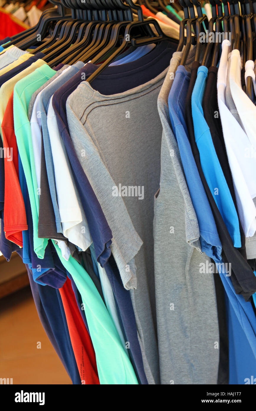 Colorful t-shirts on the hanger in the clothes shop Stock Photo