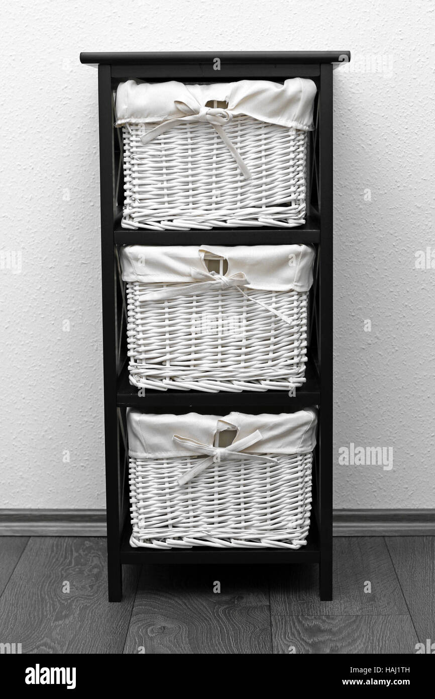 brown shelf with wicker baskets at white wall Stock Photo Alamy