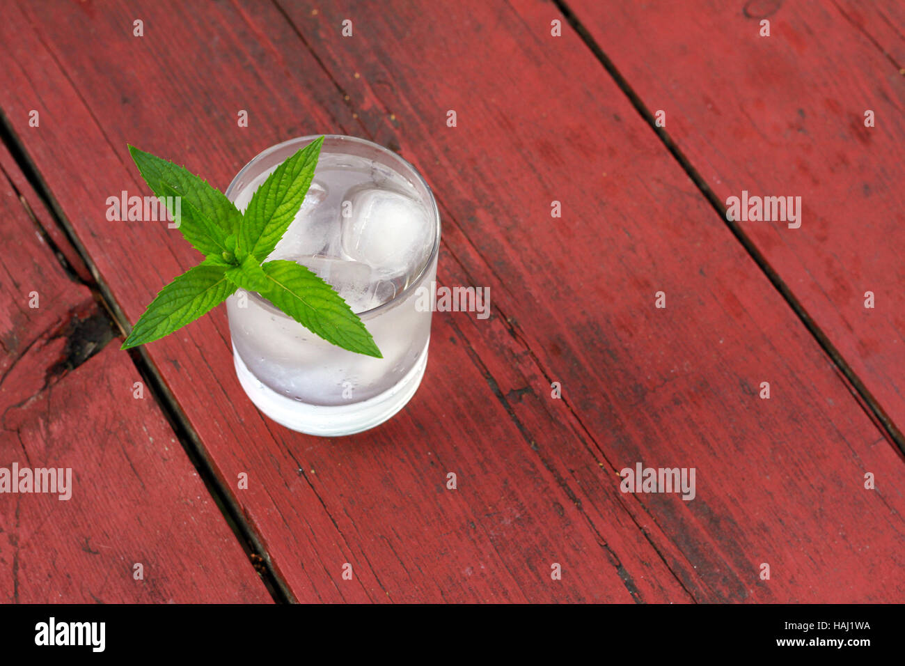 glass of cold water with ice and mint on old wooden table Stock Photo