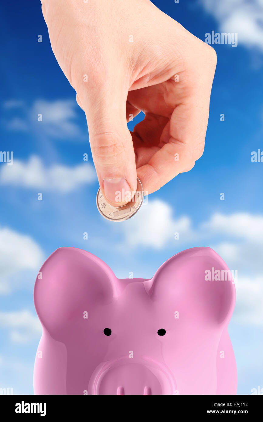 hand putting a coin into piggy bank Stock Photo - Alamy