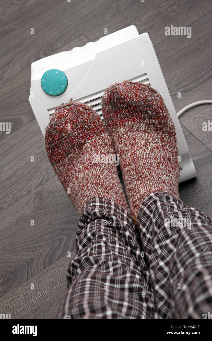 feet with wool socks and electric heater Stock Photo