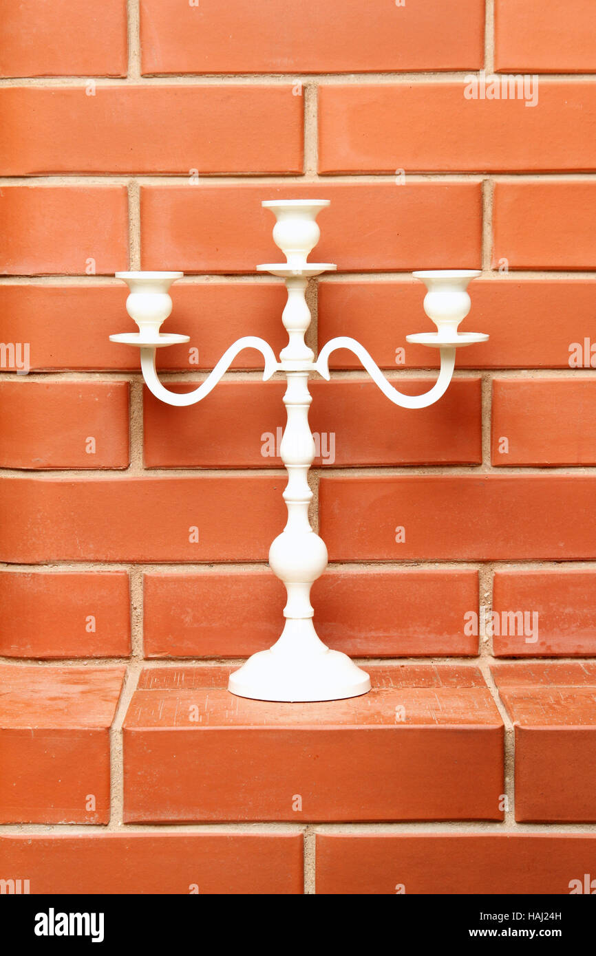 white candlestick on the brick background Stock Photo