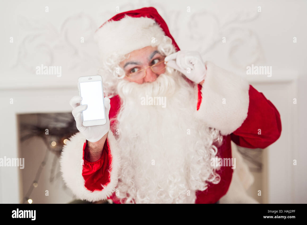 Santa Claus shows a smartphone on white background Stock Photo - Alamy