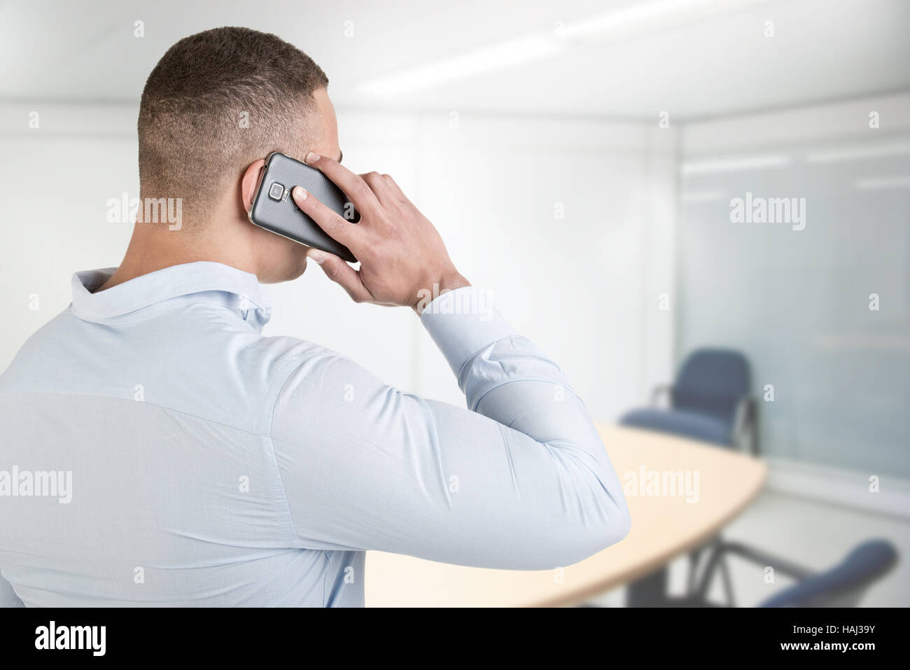 Young man talking on the phone, in an office Stock Photo