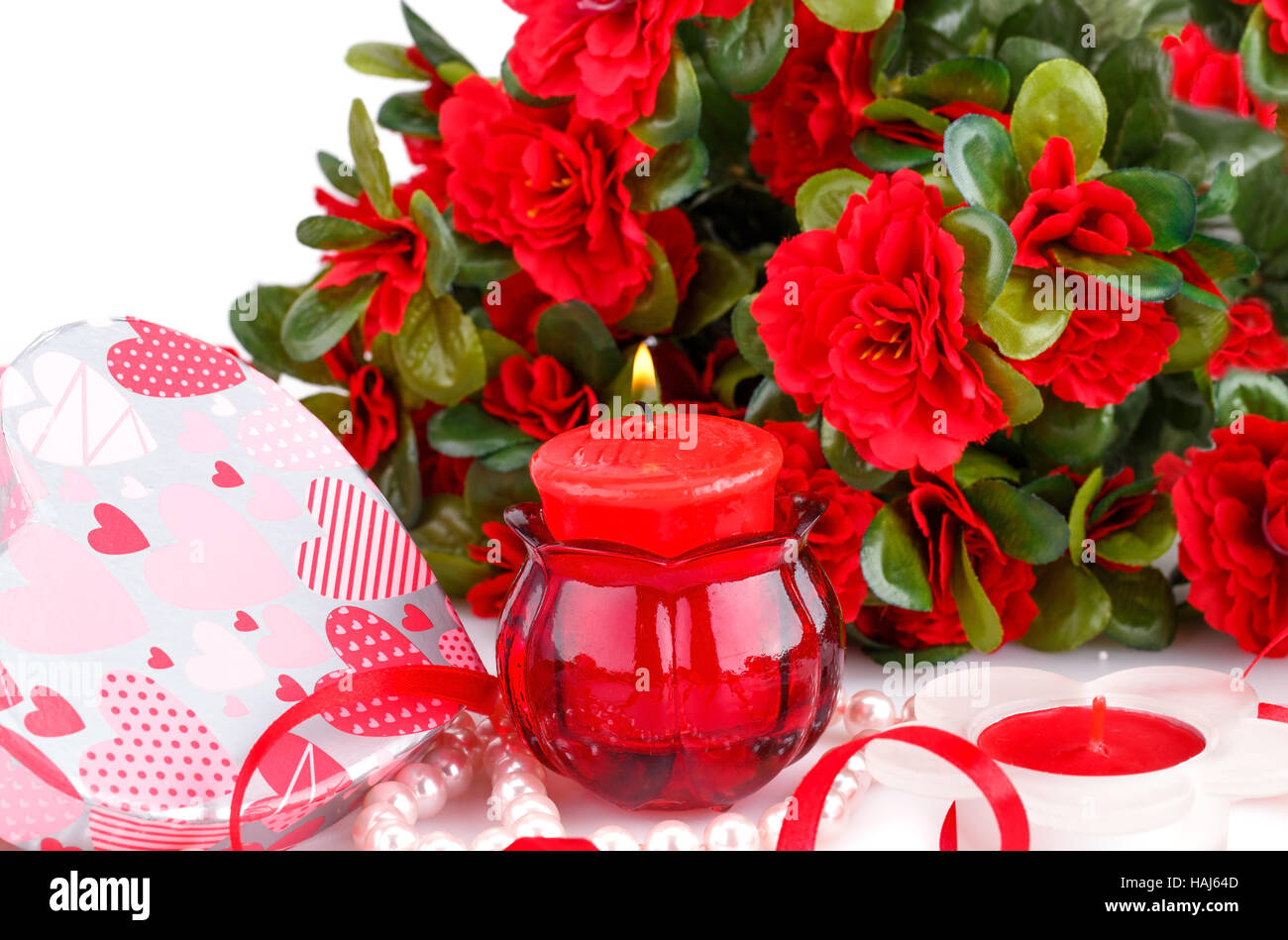 Red flowers, candles and gift box close up picture. Stock Photo