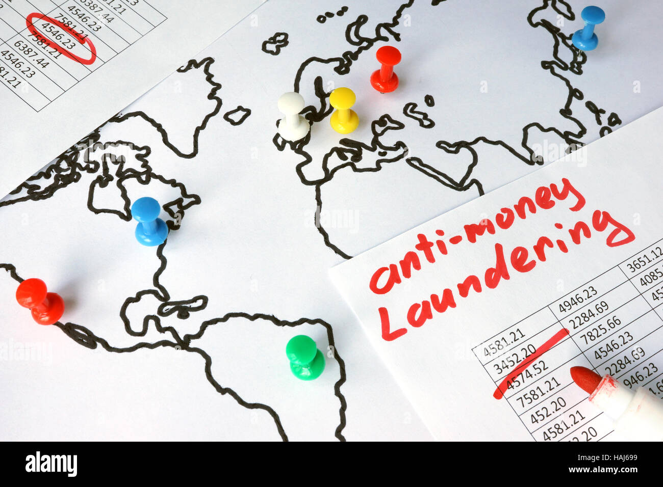 Anti-money laundering (AML) concept. Data and thumb tacks in a map. Stock Photo