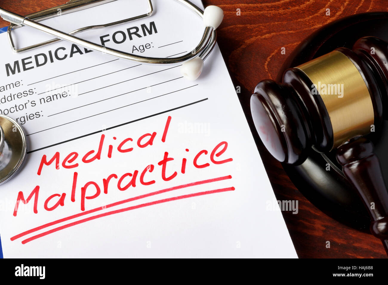 Medical form with words Medical Malpractice and gavel. Stock Photo