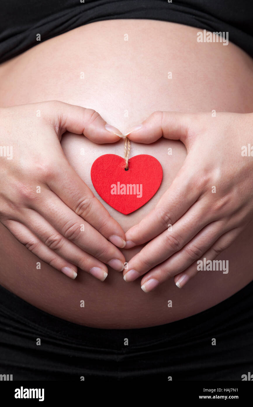 Portrait of a pregnant woman holding her belly Stock Photo - Alamy