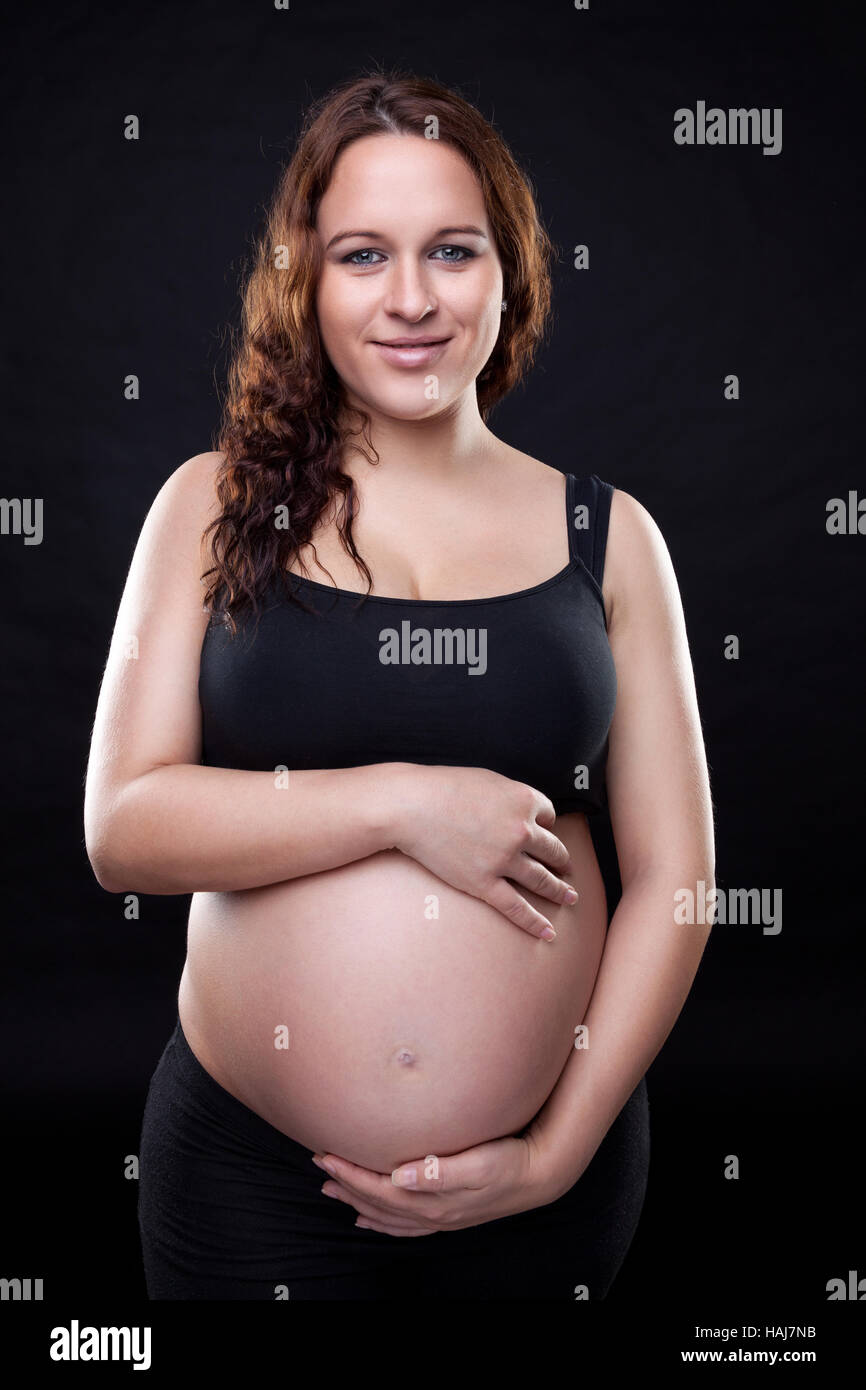 Portrait of a pregnant woman holding her belly Stock Photo - Alamy