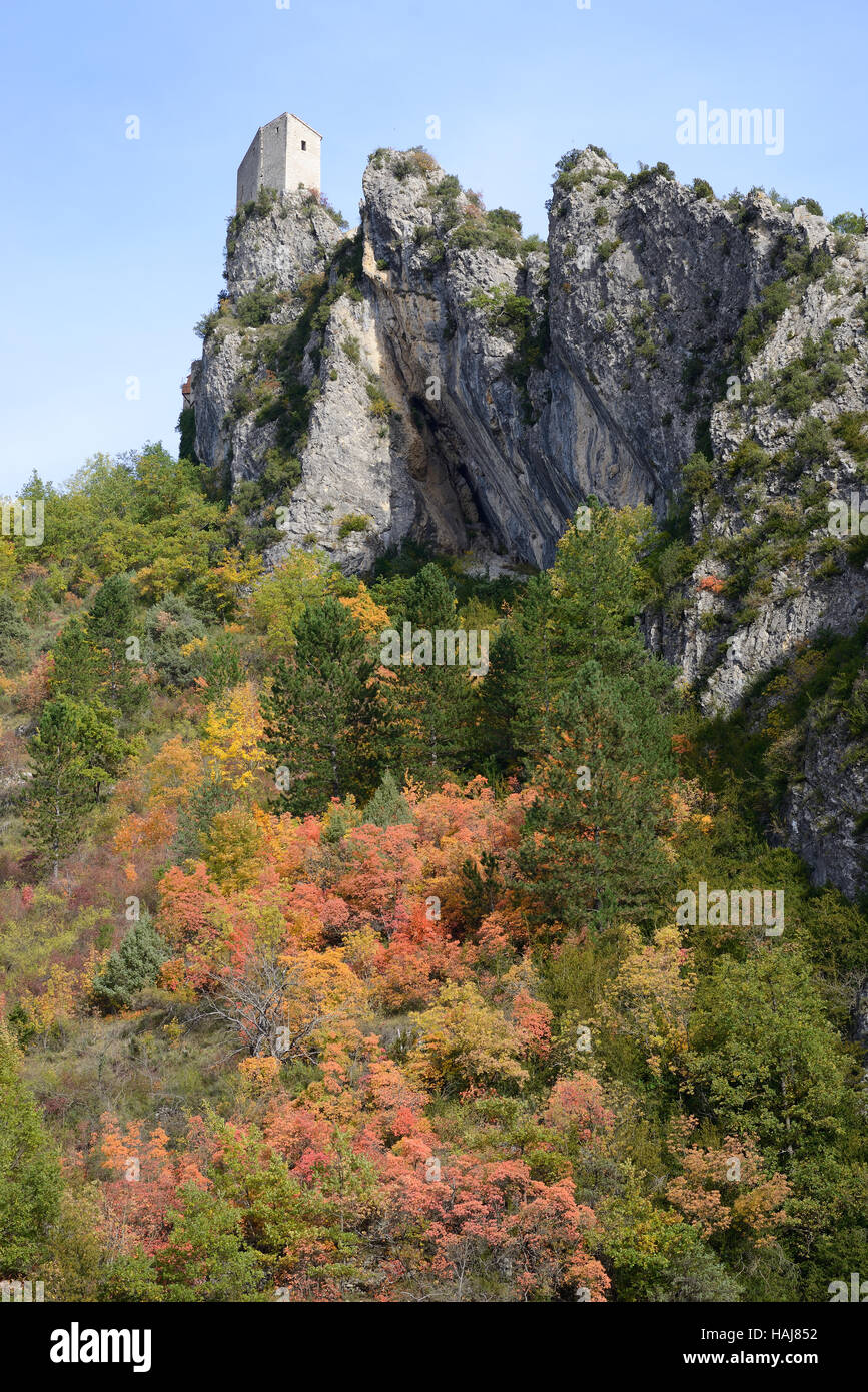 Castle perched on top of a precipitous cliff overlooking a forest with autumnal colors. Entrevaux, Alpes de Haute-Provence, France. Stock Photo